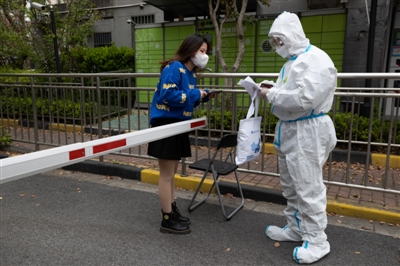 4月5日，在上海市世博家园，送货员叶义飞（右）把一款增强术后免疫能力的新特药交接给患者女儿。疫情封控期间，特殊药品的供应显得尤为重要。新华社发
